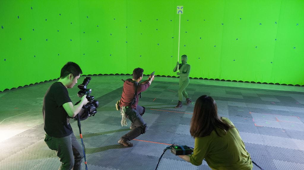Students filming two people in a large room with green walls
