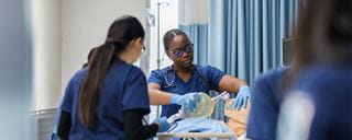 Nursing students practicing on a mannequin