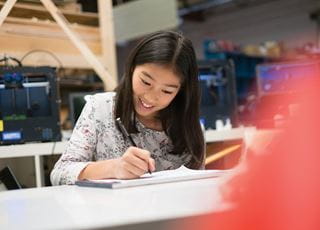 Young girl smiling and drawing