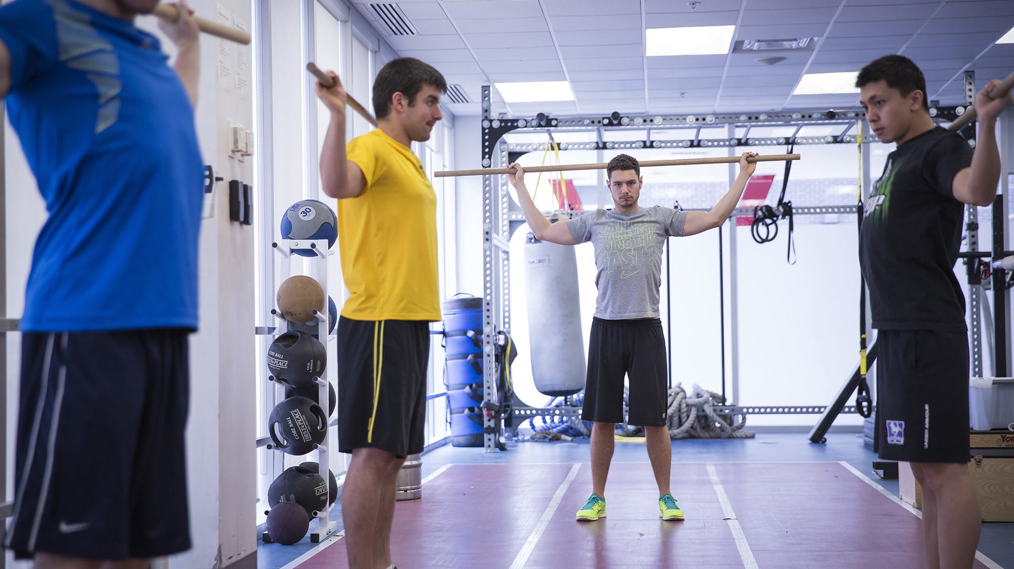 Students with therapy sticks in a room with exercise equipment