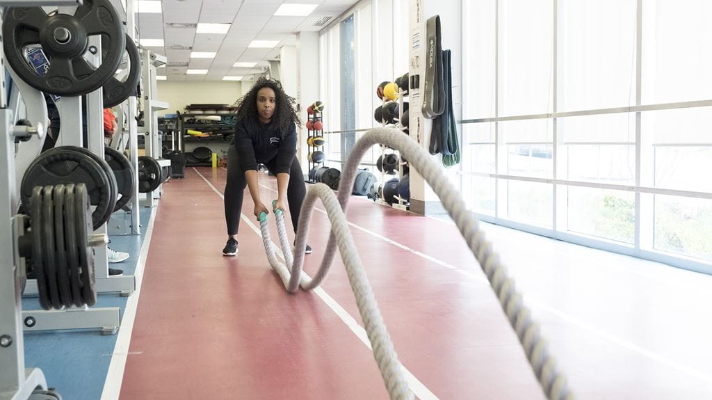 An athlete doing battle rope exercises in Sheridan's Strength and Conditioning Facility