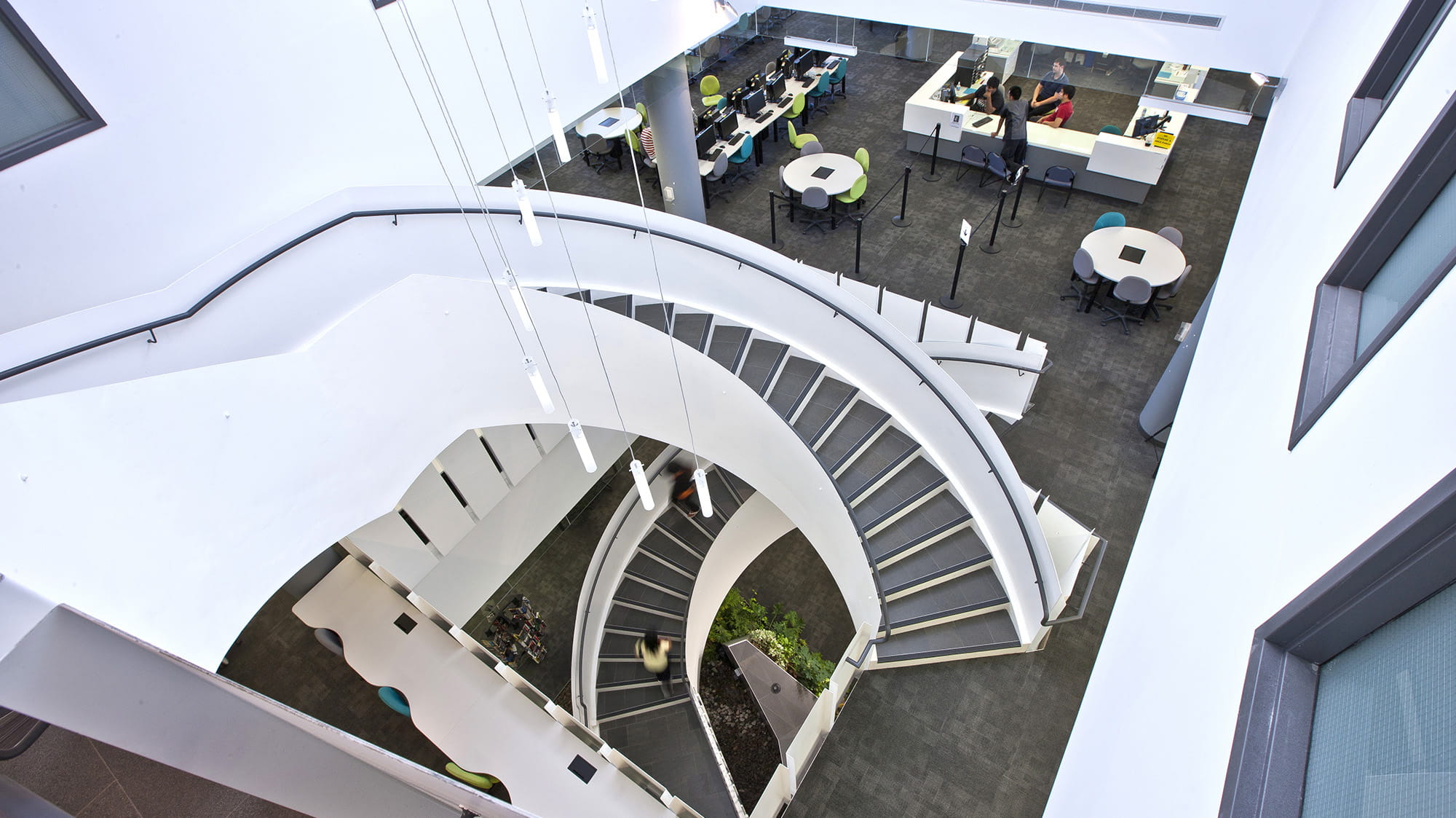 The bright white spiral stairs at the library as seen from the top