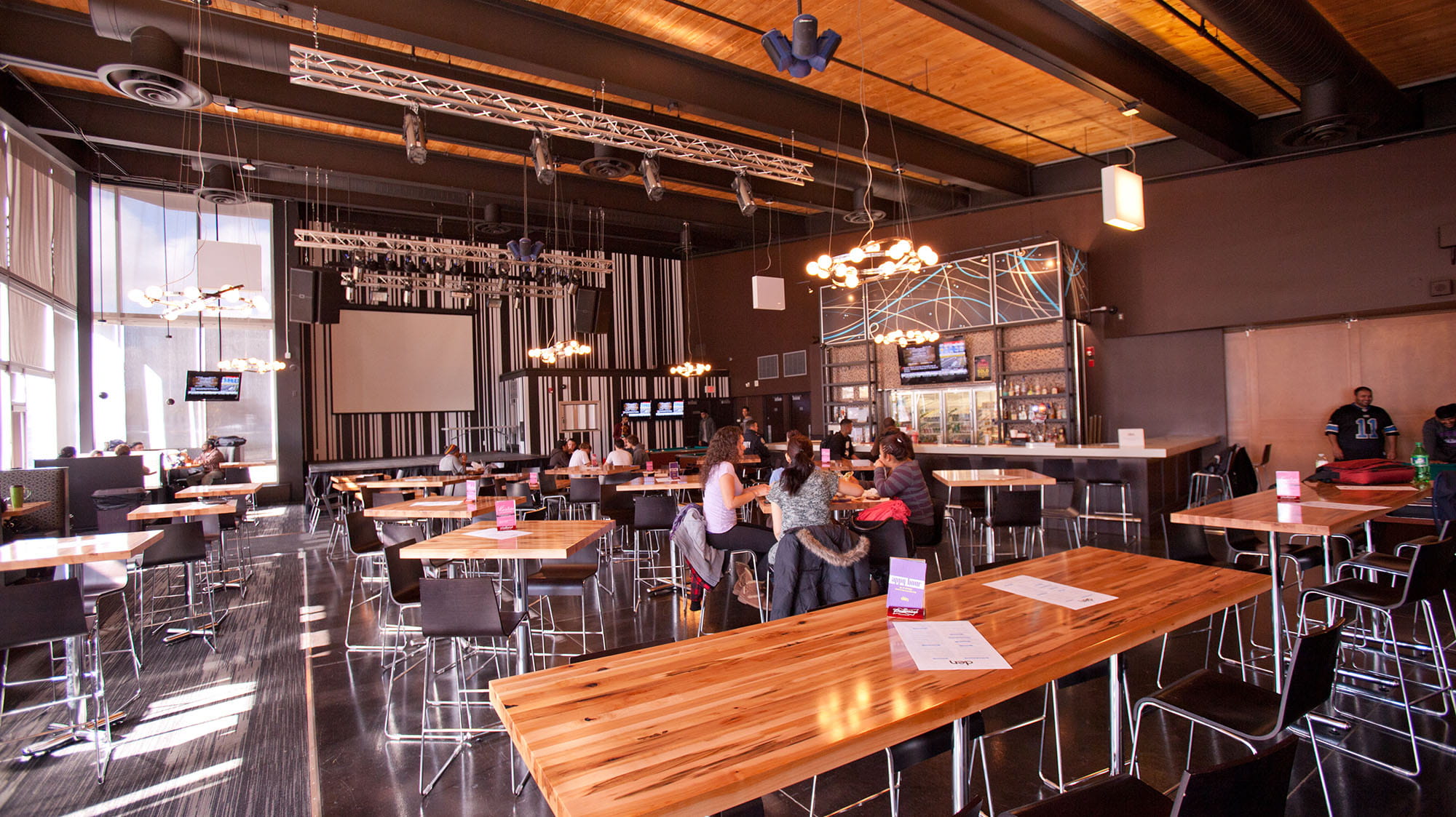 Students eating at tables in Sheridan's pub, The Den