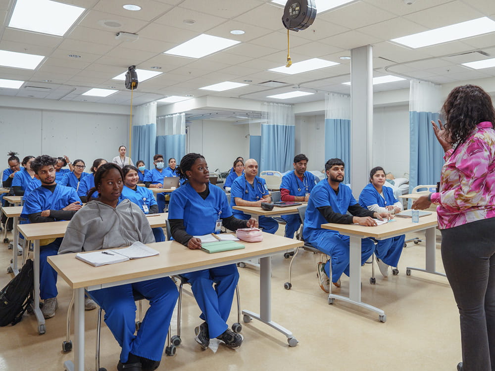Students seated in a classroom watching a lecture.