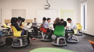 Students sitting on brightly coloured chairs in the Faculty Collaboratory