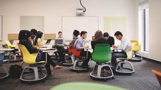 Students sitting on brightly coloured chairs in the Faculty Collaboratory