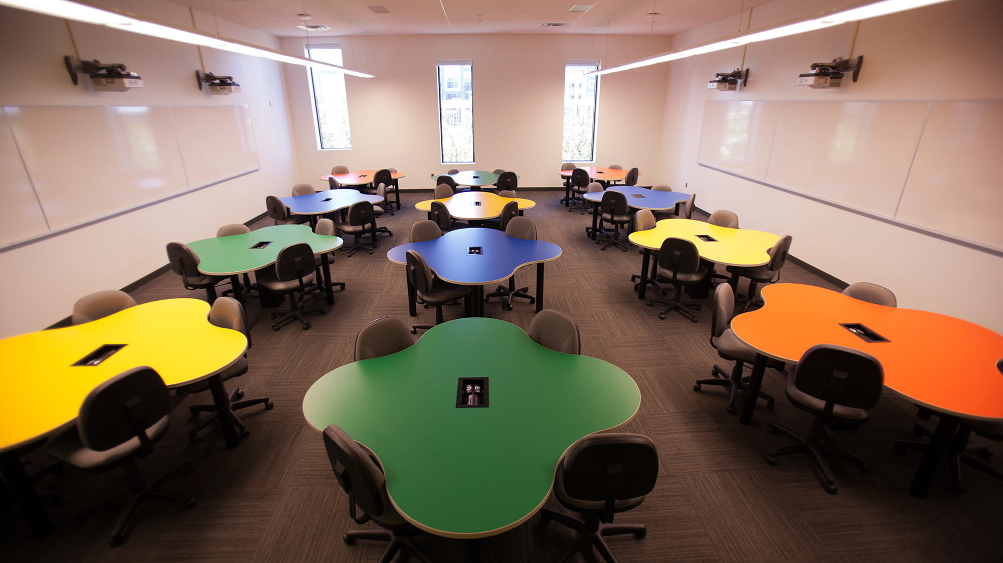 A room with multicoloured amoeba-shaped tables.