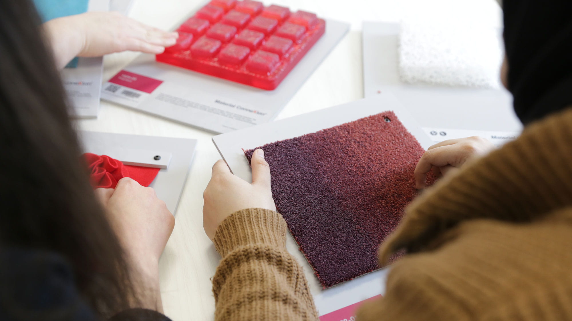 Students sit at a table looking at samples from Sheridan's Material ConneXion Library.