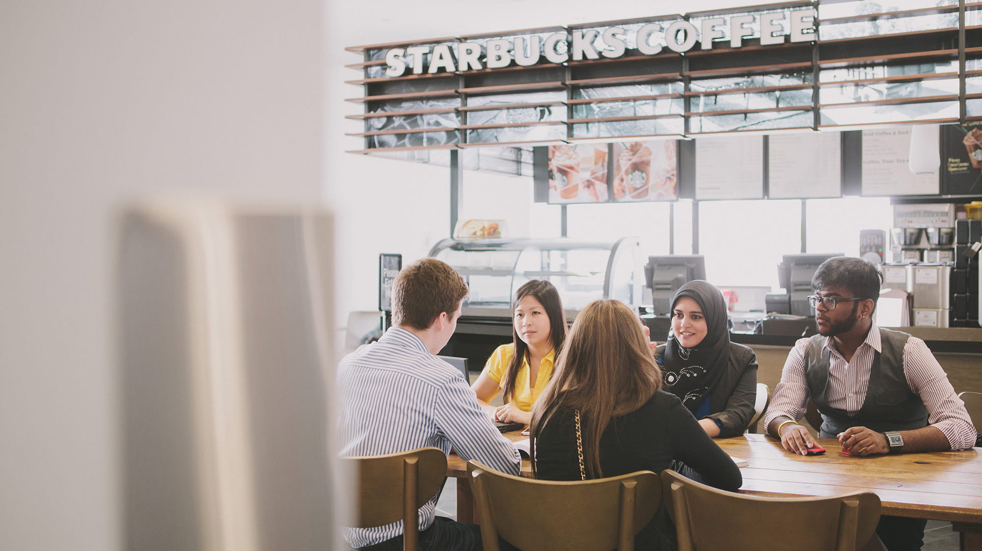 A group of students sitting at a table at Starbucks.