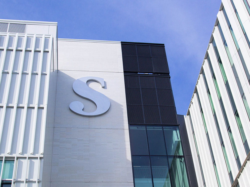 Looking upwards at the Sheridan 'S' on the exterior of the Student Centre at Hazel McCallion Campus.
