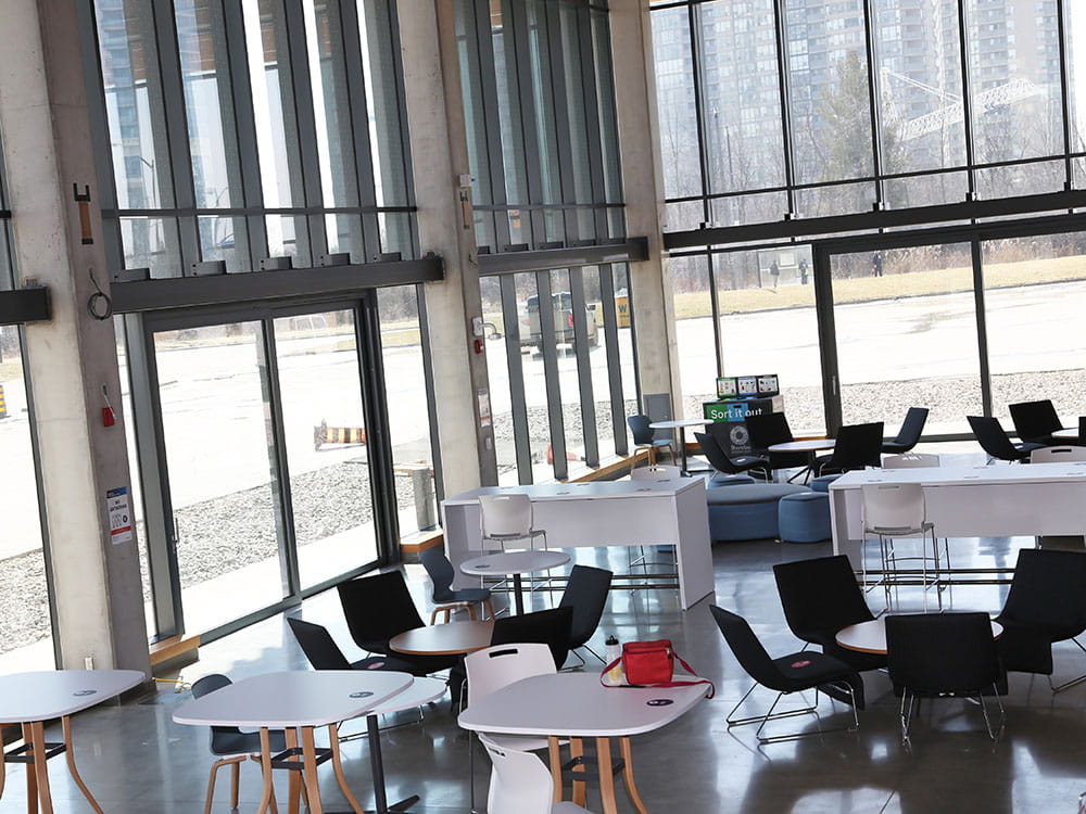 Looking down at the lounge surrounded by glass windows in the Student Centre at Hazel McCallion Campus.