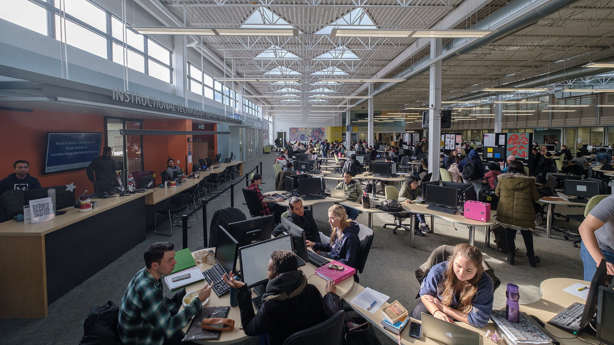 Groups of students working at tables inside the Learning Commons