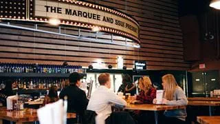 Students eating at a table by the bar in the Marquee