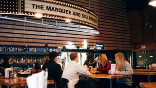 Students eating at a table by the bar in the Marquee
