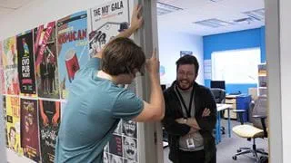 Some students smiling and hanging around at the door of the Student Union