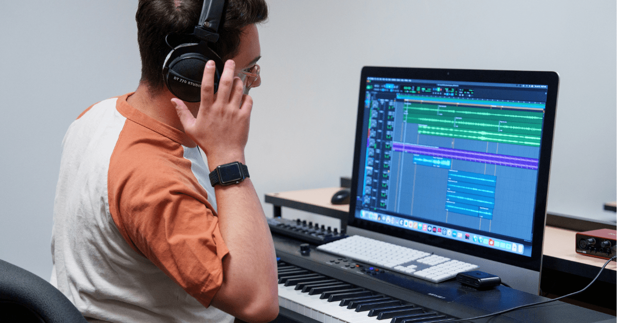 A person with headphones on looking at a computer
