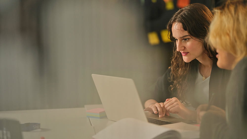 Two people looking at a laptop monitor