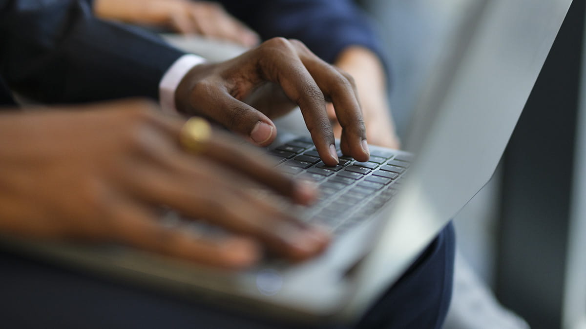Hands typing on a laptop keyboard