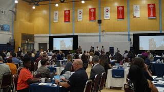 People seated around tables at a conference