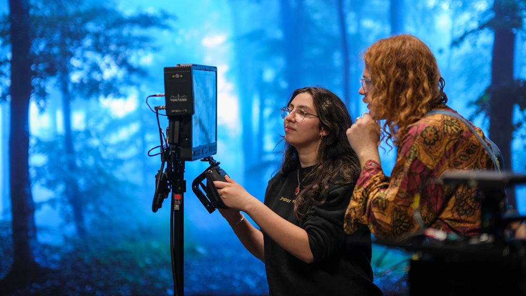 Two students looking at a video monitor