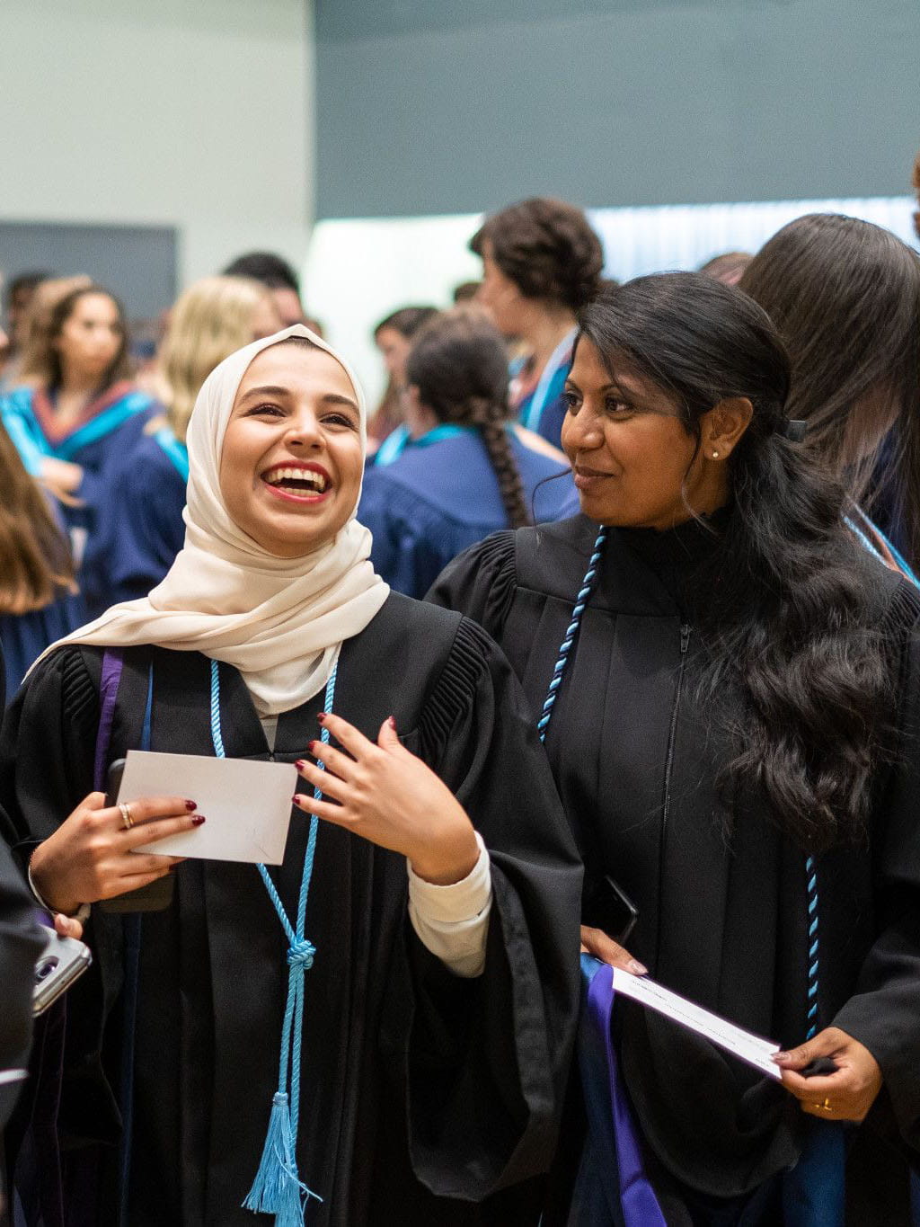 Two graduates smiling in their gowns