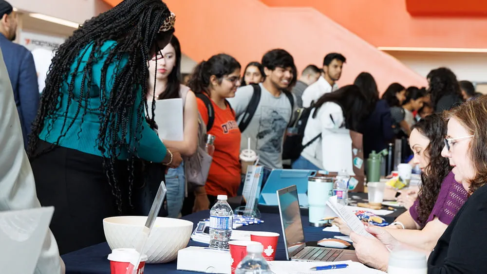 People standing at a table with others seated on the opposite side of the table