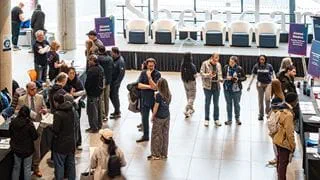 People walking around inside the lobby area of a building.