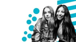 Two students standing side-by-side and smiling