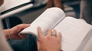 Closeup of a person's hands holding an open book