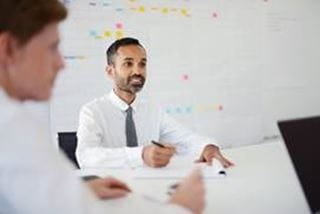 A person sitting at a table and taking notes.