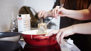 Food cooking in a frying pan on a stove