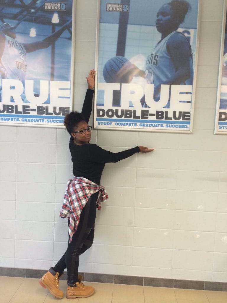 Shylanda Saunders posing in front of her Double-Blue poster
