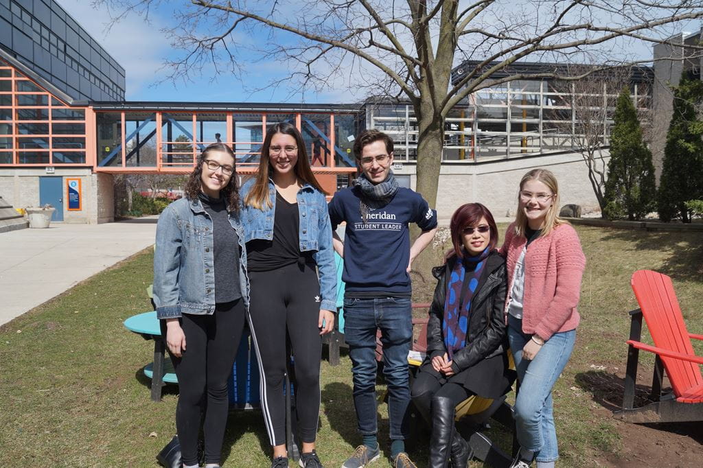 Five Sheridan degree students standing in the sun outside on Trafalgar Campus
