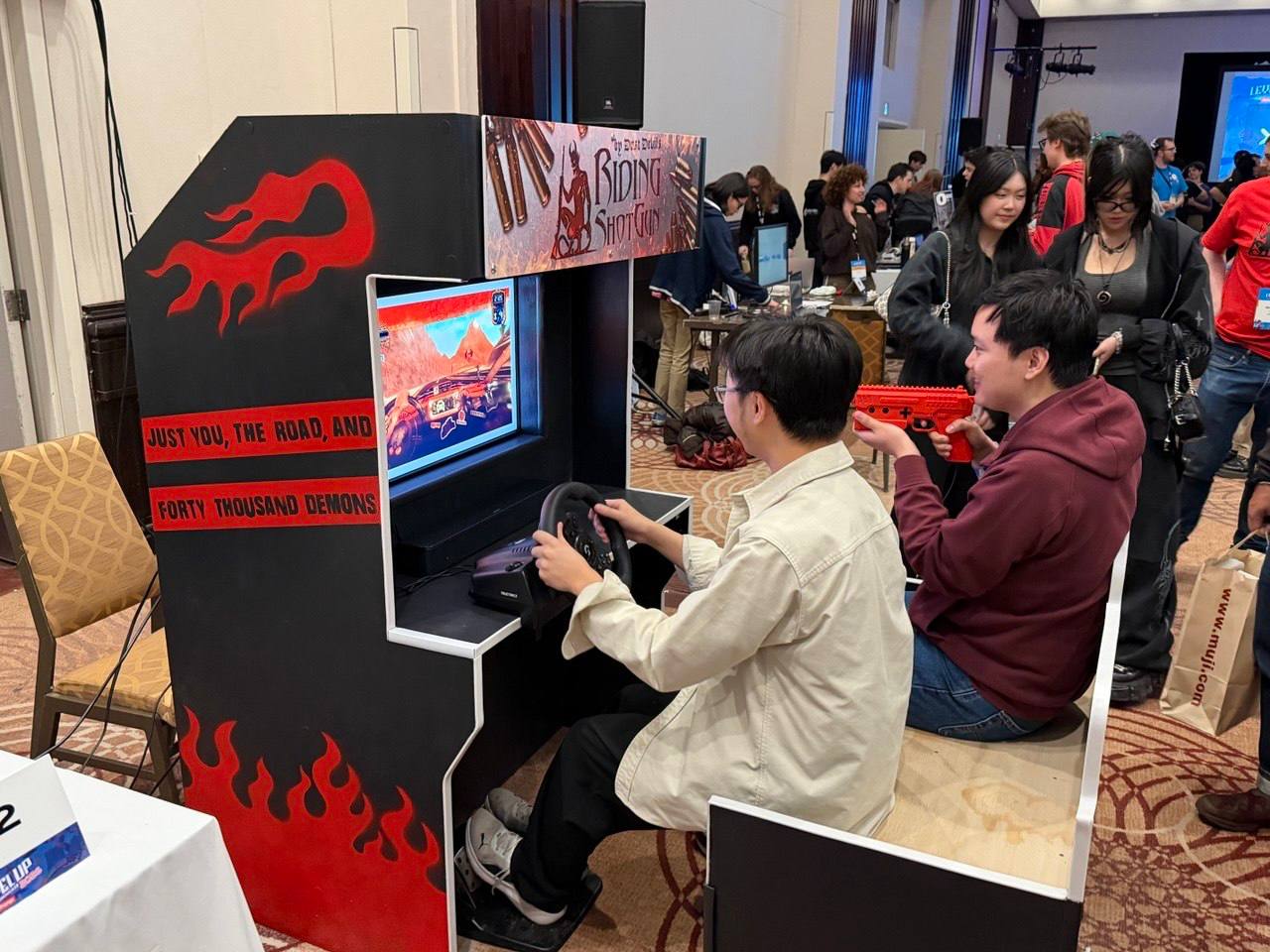 Two people sit at a console to play the Riding Shotgun video game at Level Up