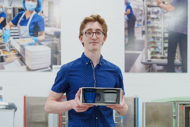 Industrial Design graduate Tobin Nickle-Lott holds samples of the cup and bowl system that he designed as a student