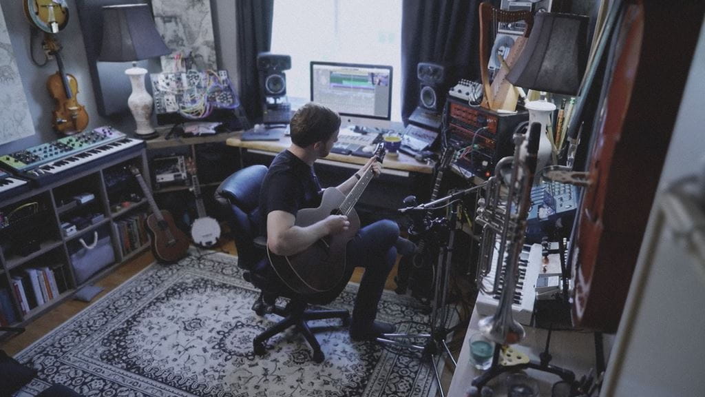 Nick ‘Walker’ Grimshaw playing guitar in his studio