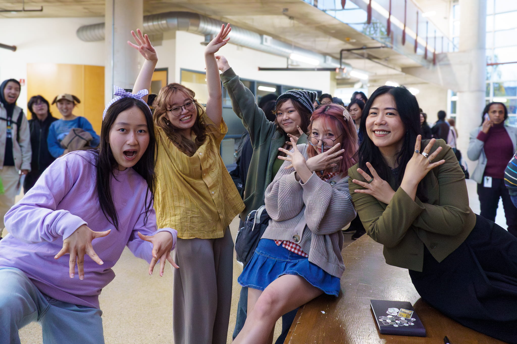 A group of animation students dressed as the main friend group in Pixar feature film Turning Red pose for a photo with Domee Shi