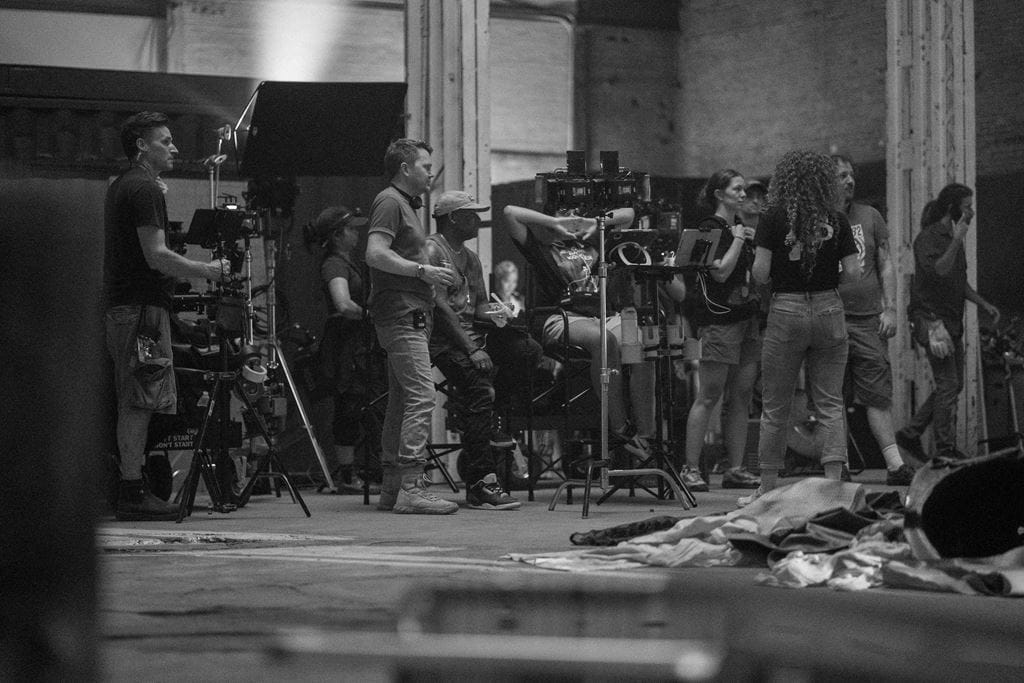 A black and white photo of people and equipment on the set of The Millwood Murders: Buried Truth