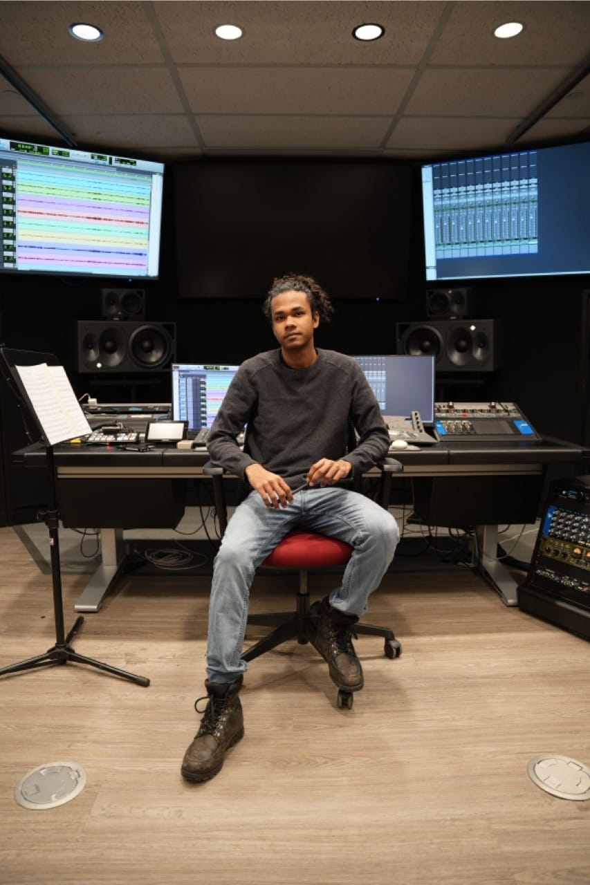 Music Scoring For Screen and Stage student Ricardo Gomes poses for a photo while seated inside one of Sheridan's recording studios
