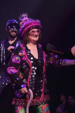 Glass artist and show creator Laura Donefer in her glass outfit on stage.