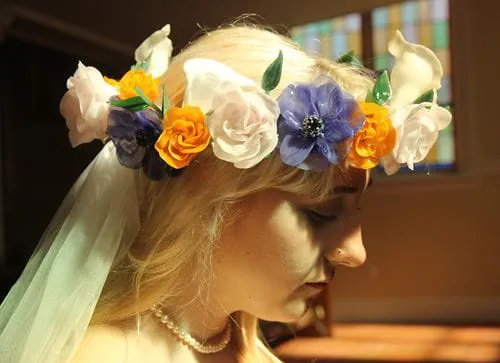 A woman wears a colourful crown of glass flowers on her head.