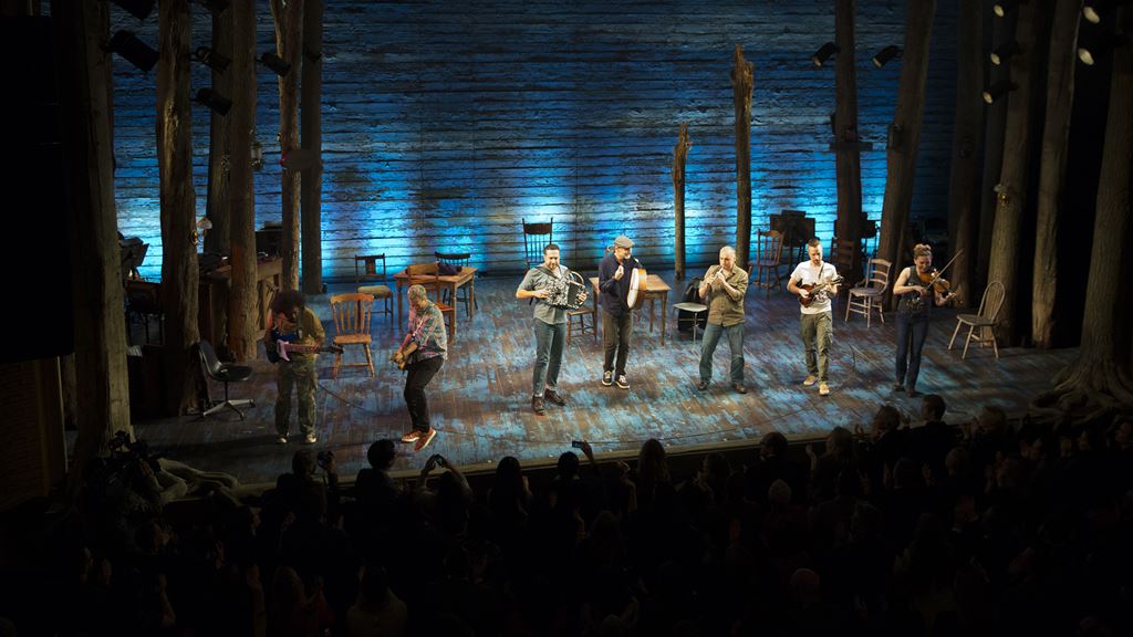 Actors performing with instruments on stage
