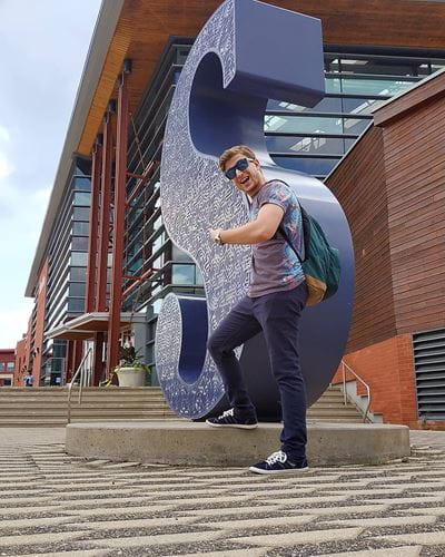 Animation Student Liad Treger stands in front of Sheridan "S"