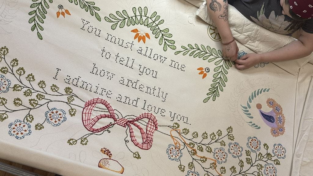 An embroidered piece that says You must allow me to tell you how ardently I admire and love you.