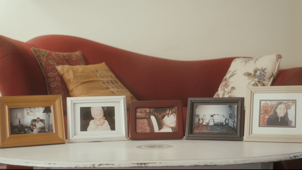 Framed photos on a table - still from the short film On the Fence