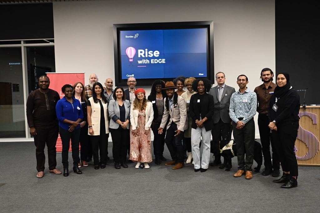 Social entrepreneur Anita Grant stands in a room with members of the Sheridan EDGE team
