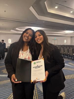 Two women posing together while holding up a certificate.