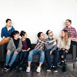 7 students laughing on couch