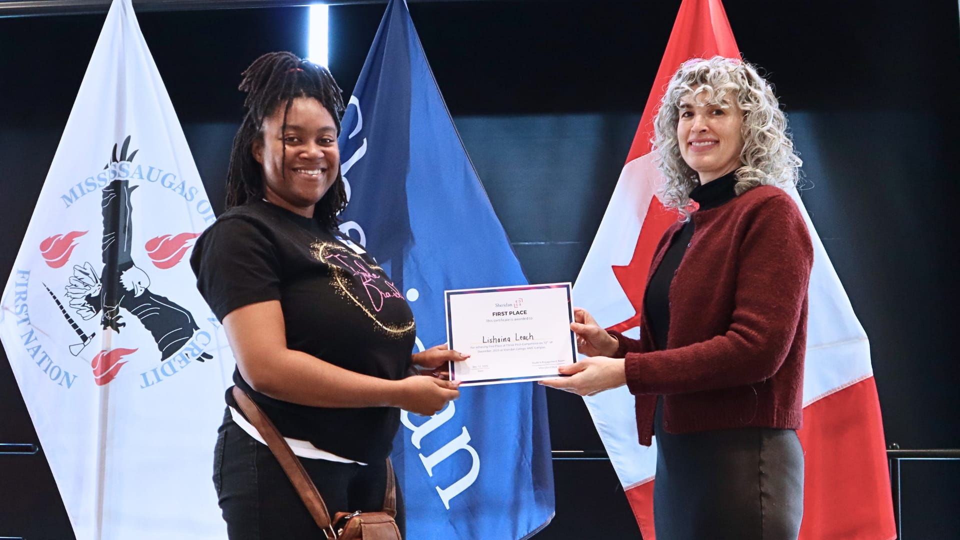 A Thrive participant is presented with a first-place certificate by a Sheridan EDGE staff member
