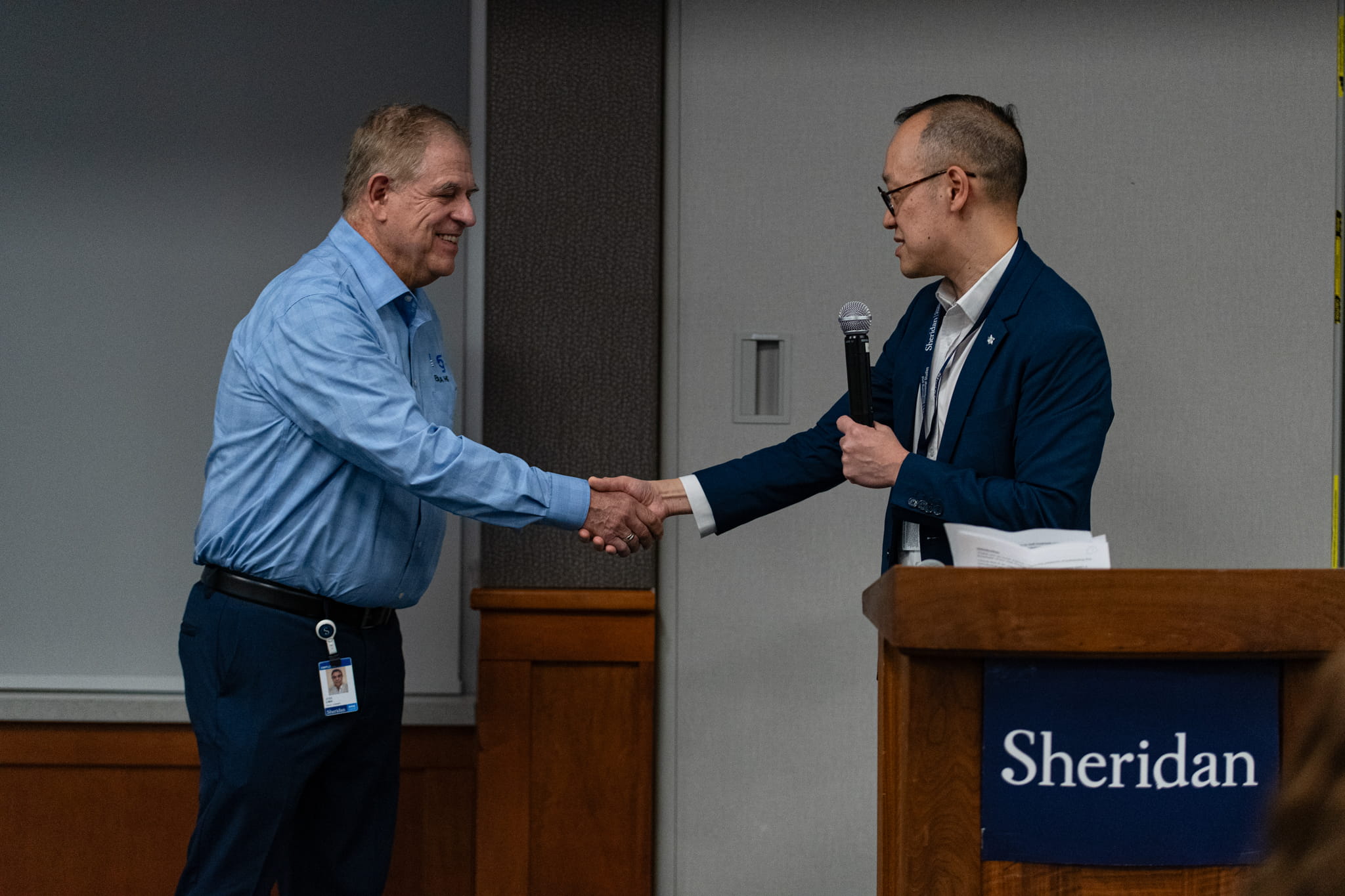 Sheridan's Direct, Industry and Professional Engagement, Arthur Kong shakes hands with a 2025 Employer of the Year Award recipient